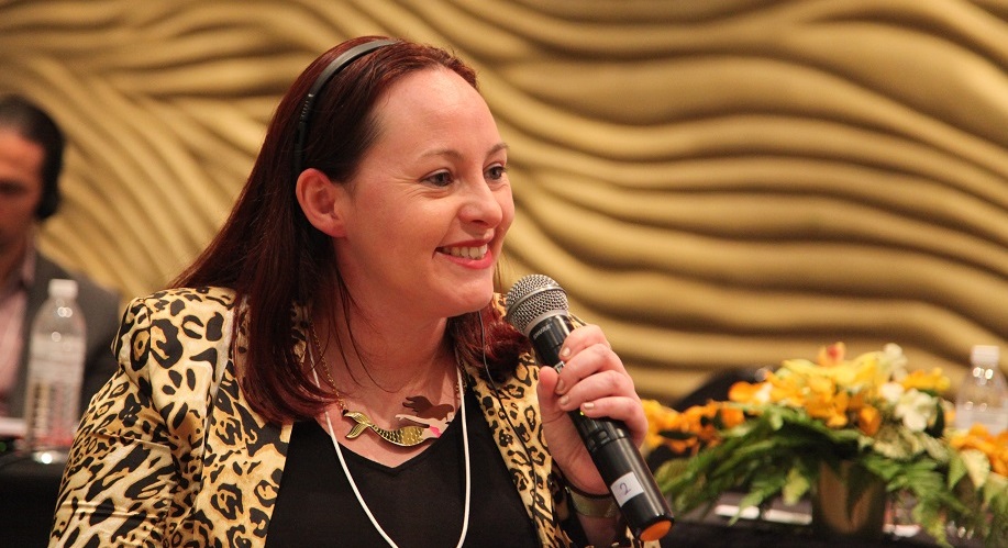 Image of Liz Hardwick holding a microphone and presenting in Malaysia